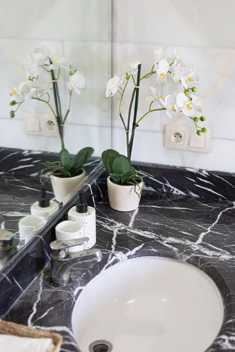 Black marble vanity with white orchids