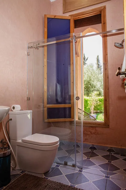 A blue-tiled shower room with garden window
