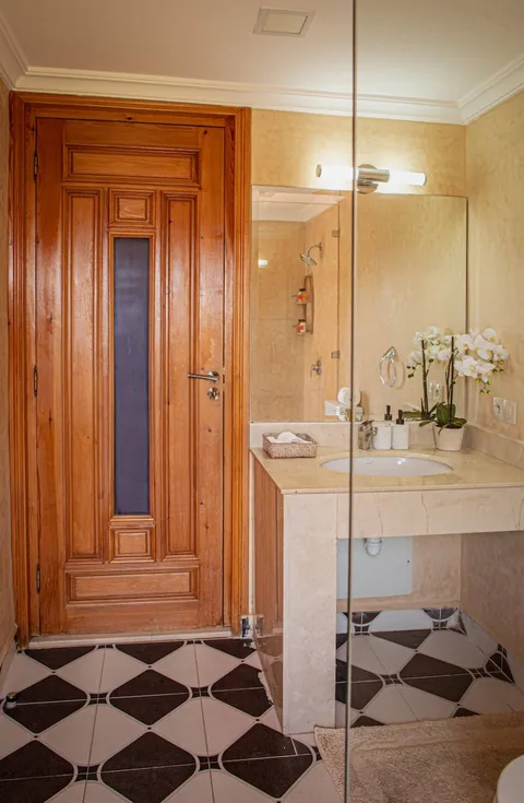 A cedar door opening to the chequerboard bathroom