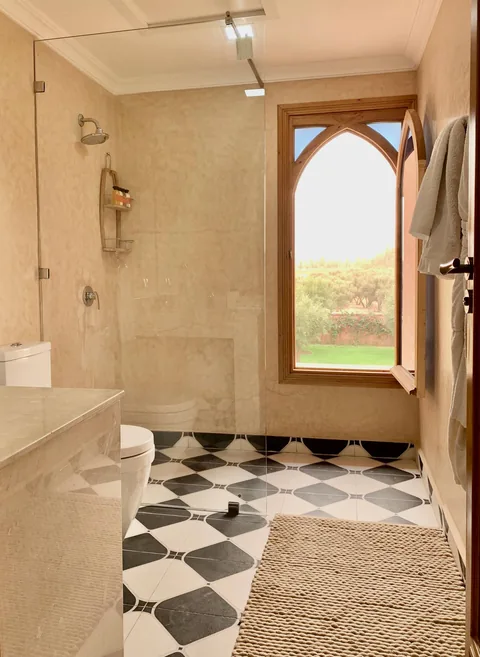 A walk-in shower and chequerboard marble floor