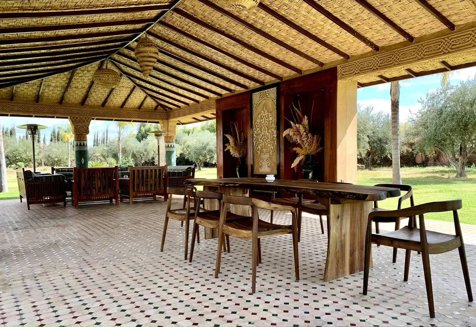 The garden dining pavilion under its reed ceiling