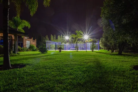 The floodlit grounds and padel court at night