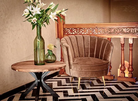 A shell chair and marble side table on a chevron floor