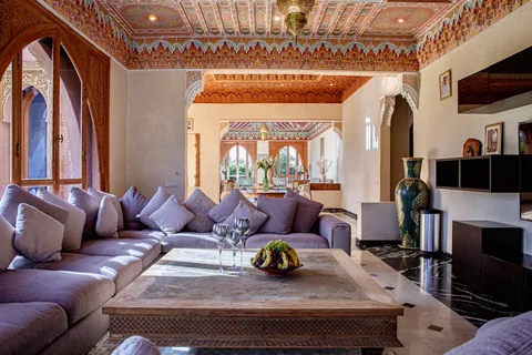 The living room seating arranged under a painted cedar ceiling