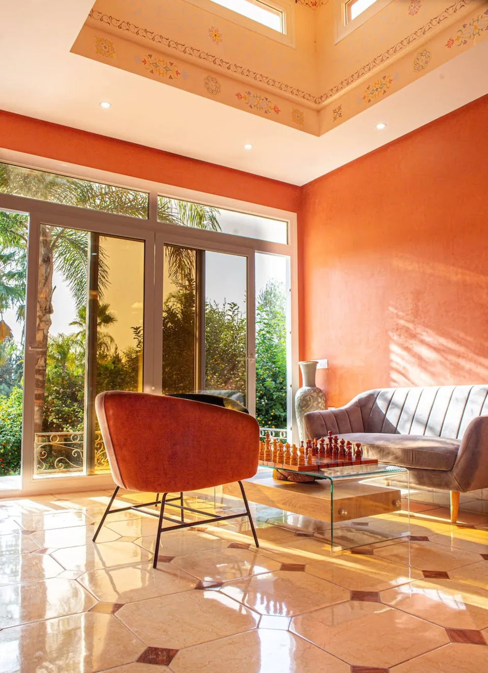 A corner lounge in warm ochre with garden doors