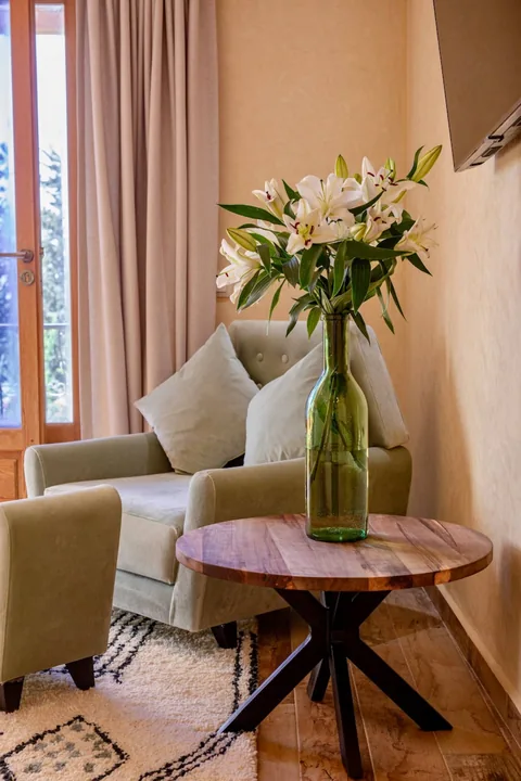 A garden-facing armchair and lilies in a suite