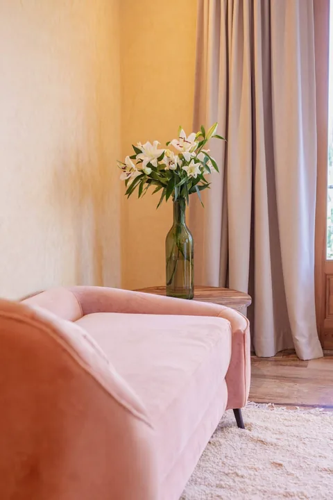 A rose armchair reading nook within a suite