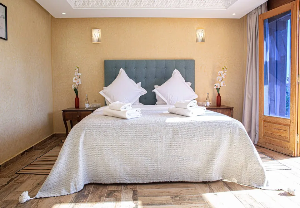 Twin beds dressed in white linen in the teal suite