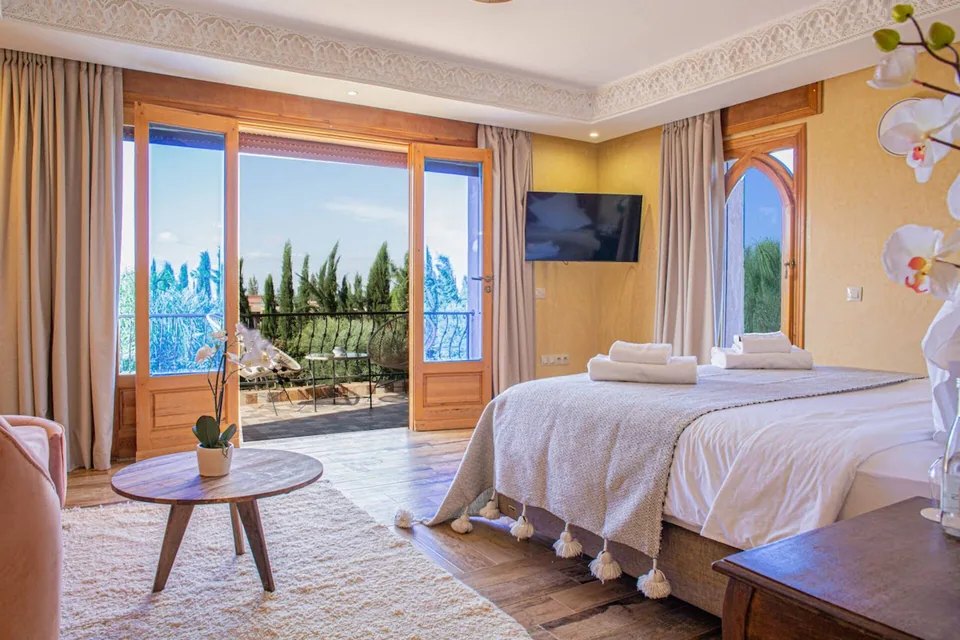 A suite opening onto its terrace with views to the Atlas